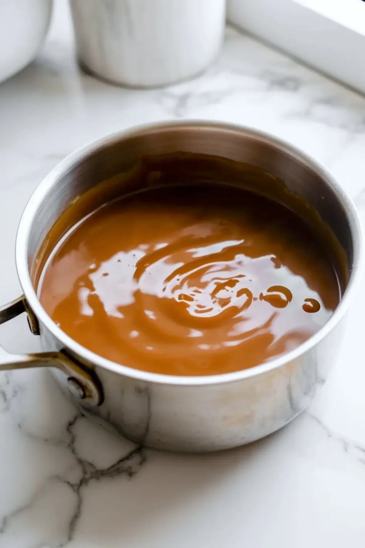 Cooked brown sugar caramel in a saucepan for praline crunch snack mix