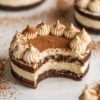 A tiramisu sandwich cookie with elegant cocoa powder dusting on top, showcasing multiple layers of chocolate cookie and mascarpone filling. The text overlay "Tiramisu Sandwich Cookies" enhances the appeal for dessert lovers looking for a refined, Italian-inspired treat.