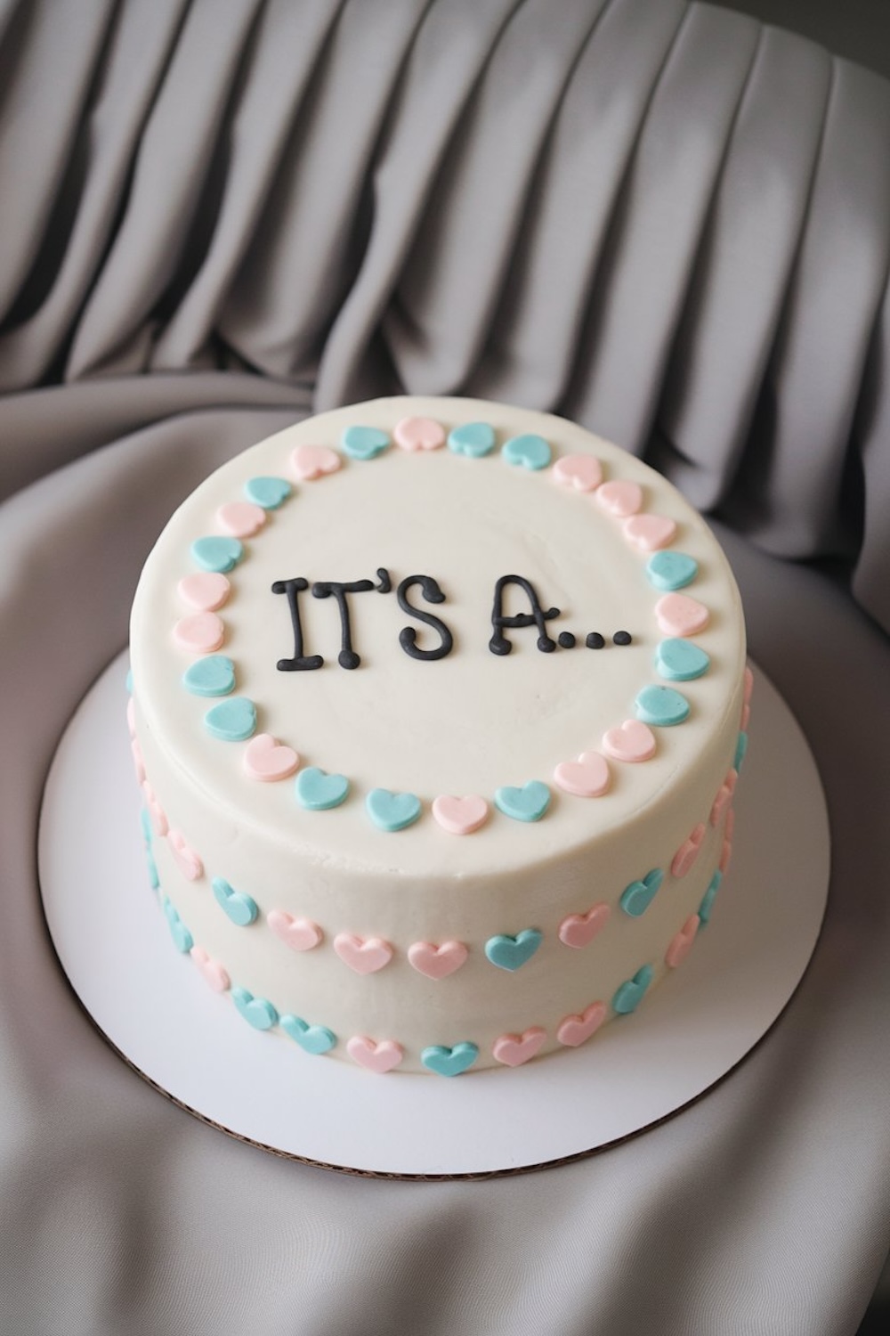 This simple yet charming cake is encircled by pink and blue hearts and leaves the reveal in suspense until the very last moment.