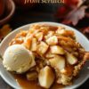 Warm caramel apple dump cake served with a scoop of vanilla ice cream, featuring a homemade crust and chunks of tender apples in a caramel glaze, perfect for fall dessert lovers.
