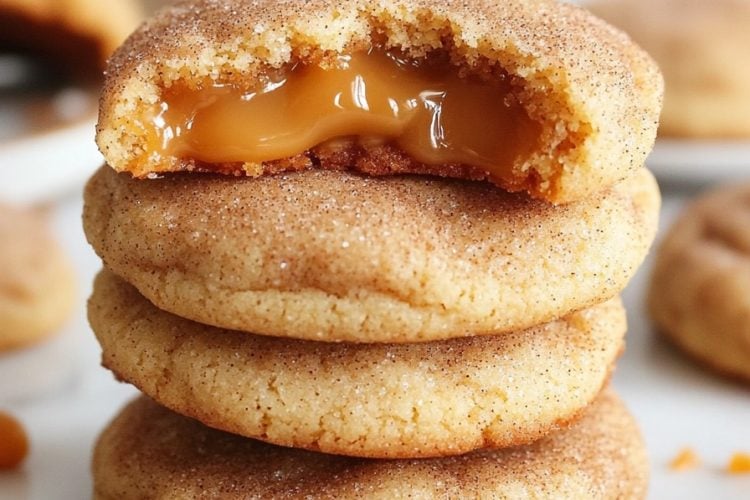 caramel stuffed cookies with caramel in the middle stacked on three rows