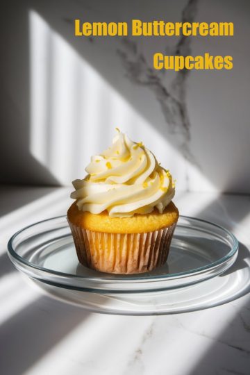 Lemon buttercream cupcakes topped with fresh zest, displayed on a marble table.