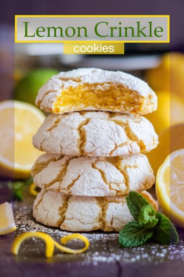 Close-up of fresh lemon crinkle cookies with a dusting of powdered sugar, showing cracks and golden edges.