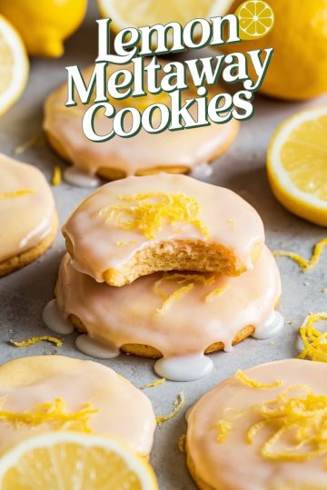 Close-up of lemon meltaway cookies topped with glaze and fresh lemon zest, showcasing their soft, citrusy texture.