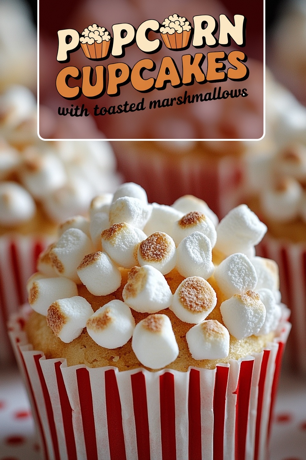 Close-up of a cupcake in a red-and-white striped wrapper, topped with lightly toasted mini marshmallows, resembling popcorn in appearance.
