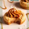 Close-up of a caramel cookie topped with a swirl of smooth caramel frosting and a sprinkle of sea salt. The cookie has a bite missing, showcasing its chewy center. The background features caramel drizzles and sea salt scattered across a white surface.