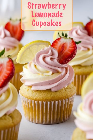 Bright and vivid image showing Strawberry Lemonade Cupcakes topped with dual-tone pink and yellow swirled frosting, garnished with fresh strawberry slices and a lemon slice, set against a light backdrop.