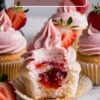 Close-up of a strawberry cupcake with pink frosting, topped with a fresh strawberry slice. The cupcake is cut open to reveal a gooey strawberry filling inside, with the text "Strawberry Surprise Cupcakes" overlayed at the top.