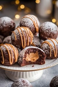 Chocolate Peanut Butter Snowballs with Caramel Drizzle – 24 Days of Christmas Desserts: Decadent chocolate snowballs filled with creamy peanut butter and topped with a caramel drizzle. These indulgent treats are dusted with powdered sugar, making them a perfect addition to the "24 Days of Christmas Desserts" collection for those who love the classic chocolate-peanut butter combination with a holiday twist.
