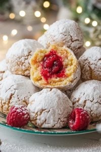 Raspberry Filled Almond Snowball Cookies – 24 Days of Christmas Desserts: Almond snowball cookies filled with a sweet raspberry center, dusted with powdered sugar for a snowy finish. These delicate, fruit-filled treats from "24 Days of Christmas Desserts" bring a burst of tart raspberry flavor to your festive cookie tray.