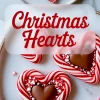 Festive heart-shaped peppermint candies with red and white swirls, featuring chocolate centers and a border of crushed candy cane, displayed on a ceramic plate with holiday-themed text overlay.