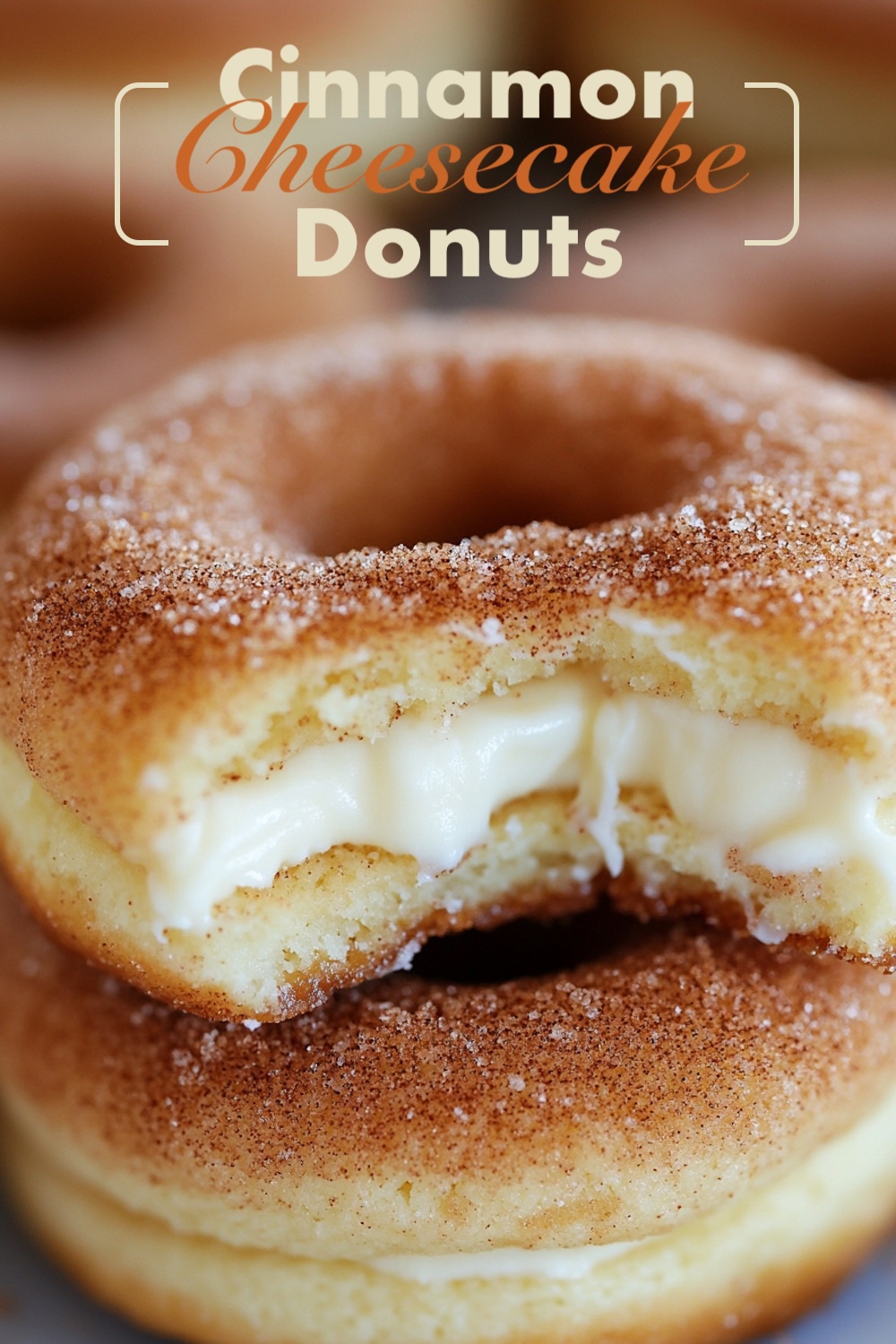 Close-up shot of a cinnamon cheesecake donut with a bite taken, revealing creamy cheesecake filling, dusted with cinnamon sugar.