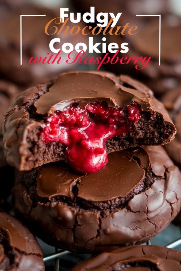 A rich chocolate cookie with a gooey, vibrant red raspberry filling oozing out from the center, covered in glossy chocolate.