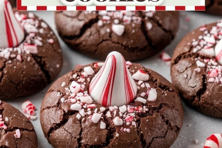 Close-up of freshly baked peppermint chocolate cookies topped with striped peppermint candies and sprinkled with crushed candy pieces, presented on a festive themed background.