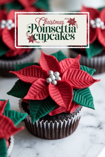 Festive chocolate cupcakes beautifully topped with red and green poinsettia petals crafted from fondant and finished with silver accents. Perfect for a holiday dessert table.