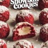 Close-up of red velvet snowball cookies on a baking sheet, showing the rich red color and coconut topping, with one cookie broken open to reveal a white cream filling.