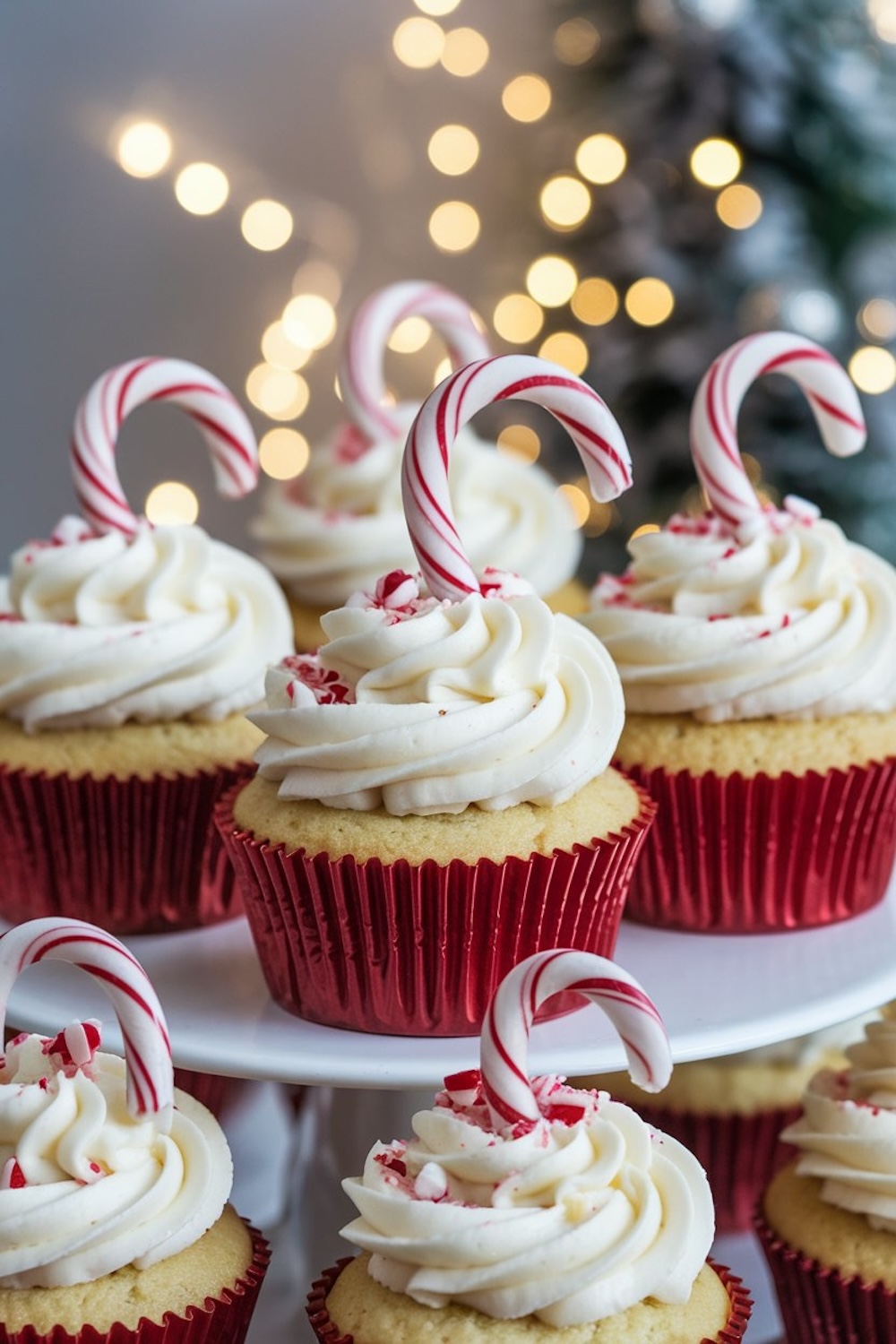 Tiered stand displaying Candy Cane Cupcakes topped with peppermint frosting, crushed candy canes, and mini candy cane sticks. A festive dessert setup perfect for Christmas parties and winter gatherings.