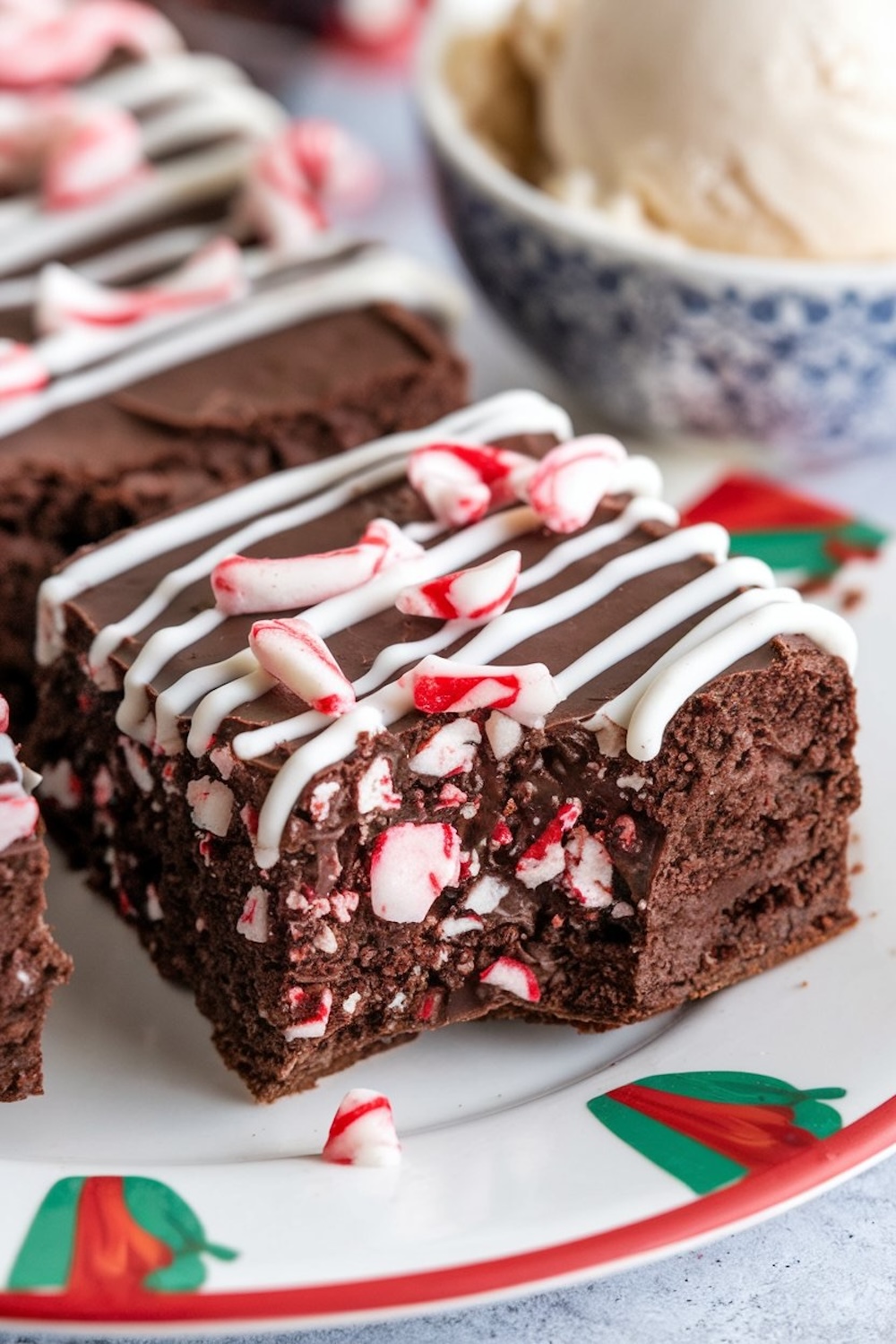 Close-up of a single peppermint brownie square, showcasing the dense, fudgy texture and crunchy peppermint topping. The brownie is finished with a white chocolate drizzle, perfect for holiday dessert plates or cozy winter gatherings.