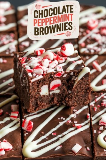 A close-up of a sliced chocolate peppermint brownie, highlighting the rich, fudgy interior and festive toppings of crushed peppermint and white chocolate. This close view captures the holiday decadence and makes an irresistible treat for seasonal celebrations.