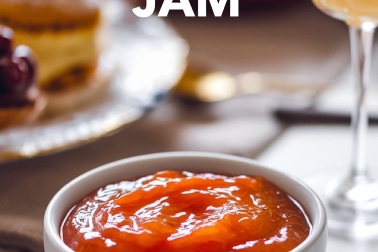 A beautifully styled breakfast scene featuring a bowl of orange jam on a table with pastries, fresh fruit, and a glass of orange juice. This orange jam is ideal for elevating any morning spread with a zesty, homemade touch.