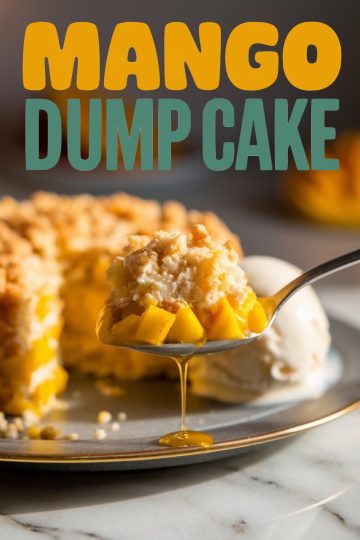 A close-up of a delicious spoonful of mango dump cake topped with a golden, crumbly crust. Chunks of vibrant, juicy mangoes peek through, while a drizzle of syrup glistens as it drips off the spoon. In the background, a scoop of vanilla ice cream and the rest of the cake add a tempting touch to this tropical dessert.