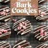 Overhead view of beautifully decorated peppermint bark cookies on a cooling rack. Each round cookie is coated in glossy dark chocolate, drizzled with white chocolate stripes, and sprinkled with crushed peppermint candy pieces for a festive touch. The "Peppermint Bark Cookies" text overlay adds a cozy holiday vibe, perfect for showcasing these seasonal treats.