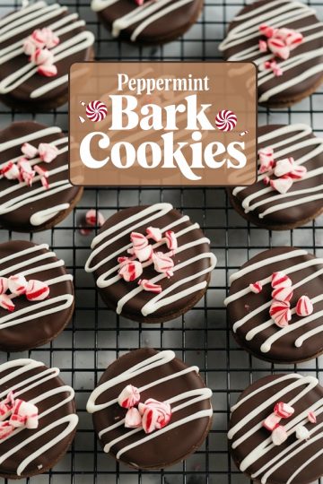 Overhead view of beautifully decorated peppermint bark cookies on a cooling rack. Each round cookie is coated in glossy dark chocolate, drizzled with white chocolate stripes, and sprinkled with crushed peppermint candy pieces for a festive touch. The "Peppermint Bark Cookies" text overlay adds a cozy holiday vibe, perfect for showcasing these seasonal treats.