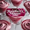 Close-up of elegant glasses filled with creamy raspberry mousse, showcasing its smooth texture and vibrant pink hues, perfect for a dessert table or festive gathering.