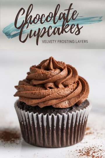A single chocolate cupcake with velvety chocolate frosting dusted with cocoa powder. The cupcake sits on a white surface, and text overlay at the top reads “Chocolate Cupcakes - Velvety Frosting Layers.”