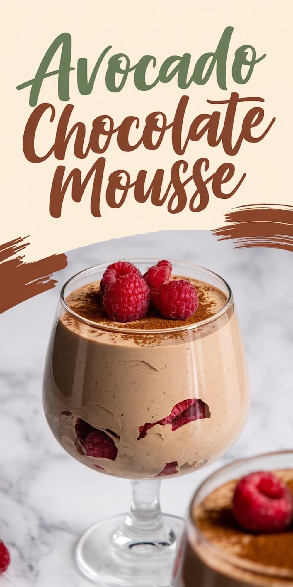A glass of creamy avocado chocolate mousse garnished with fresh raspberries and dusted with cocoa powder. The dessert features visible raspberry pieces inside, adding vibrant color. Text overlay reads “Avocado Chocolate Mousse” with artistic brushstroke accents.