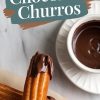 A single churro dipped in glossy melted chocolate, placed on a stack of churros. A bowl of chocolate sauce sits in the background. The text overlay “Chocolate Churros” highlights the crispy texture and rich chocolate. Designed as an eye-catching representation of the dessert.