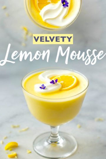 A glass of lemon mousse topped with whipped cream, a lemon slice, and small purple flowers, with the text “Velvety Lemon Mousse” overlaid on the image.