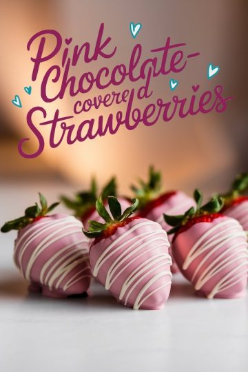 Pink chocolate-covered strawberries decorated with white chocolate drizzles, displayed against a warm blurred background, with the text “Pink Chocolate-covered Strawberries.”