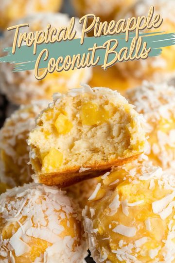 Close-up of pineapple coconut balls with one ball cut in half, showcasing the creamy interior with visible pineapple chunks. The balls are coated in shredded coconut and have a golden tropical appearance, perfect for highlighting their tropical-inspired flavors.