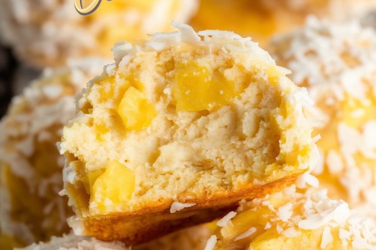 Close-up of pineapple coconut balls with one ball cut in half, showcasing the creamy interior with visible pineapple chunks. The balls are coated in shredded coconut and have a golden tropical appearance, perfect for highlighting their tropical-inspired flavors.