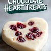A single heart-shaped white chocolate Valentine’s dessert with dried cranberries, placed on a dark surface. The smooth, creamy chocolate paired with vibrant red cranberries makes this a perfect treat for celebrating love.