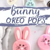 Close-up of pastel pink bunny-shaped Oreo pops with edible decorations. The bunnies have white candy ears, black whiskers drawn with an edible marker, chocolate chip eyes, and a pink candy nose. Text overlay reads “Bunny Oreo Pops” with a website link “emmascakestudio.com.”
