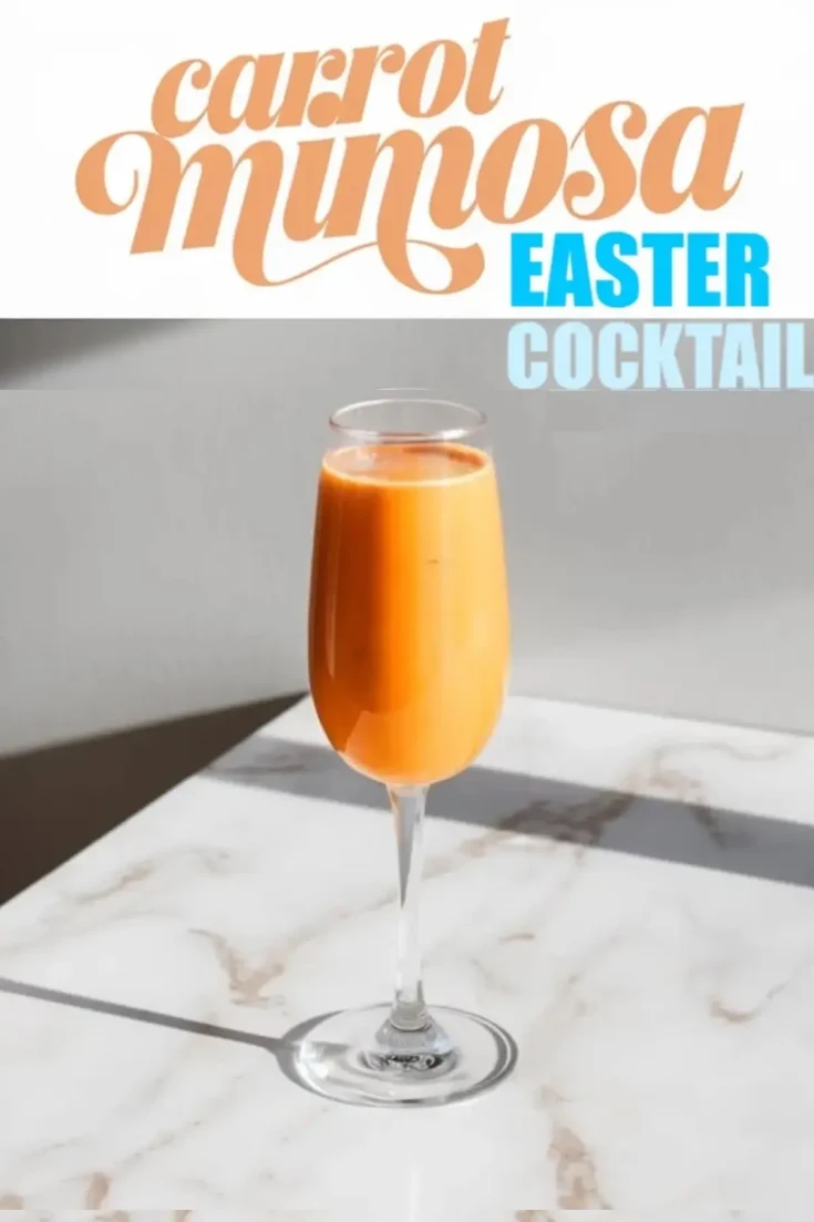 Carrot mimosa in a champagne flute on a marble surface, illuminated by natural light. The vibrant orange drink contrasts with the sleek, elegant background. Bold text above reads “Carrot Mimosa Easter Cocktail,” emphasizing its festive, springtime appeal.