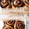 A pan filled with warm, golden chocolate cinnamon rolls, each topped with a drizzle of melted chocolate. The rolls are arranged in a baking dish, and a soft brushstroke-style text overlay reading “chocolate cinnamon rolls” adds a homemade aesthetic.