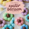 Colorful Easter blossom cookies with pastel petals and chocolate centers arranged on a white plate. The cookies feature a sugar-dusted finish, and the text overlay reads “Colorful Easter Blossom Cookies.”
