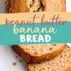 Close-up of a freshly baked peanut butter banana bread loaf with a golden brown crust, slightly cracked on top, revealing a soft, moist interior. Three slices are cut and arranged on a white plate. A colorful text overlay in handwritten font reads “Peanut Butter Banana Bread.”