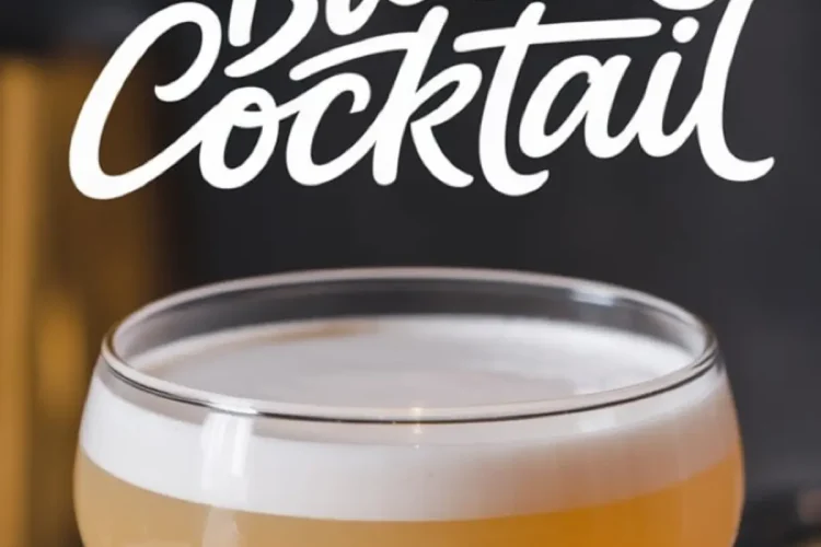 Spring Bloom Cocktail in a coupe glass with a creamy white foam atop a golden-yellow liquid. The backdrop features blurred bar tools and the text “Spring Bloom Cocktail” in bold, flowing script.