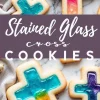 A close-up of stained glass cross cookies with rich, jewel-toned centers in turquoise, pink, and purple. The glossy centers resemble stained glass, contrasting with the crisp, golden cookie edges. The text overlay highlights the cookie theme, reinforcing their festive and decorative appeal.