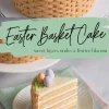 A decorated Easter basket cake with woven frosting texture, topped with edible grass, pastel candy eggs, and flowers. Below, a slice of the cake is plated on a white dish with gold trim, showing its layered vanilla sponge and creamy filling. The text overlay reads “Easter Basket Cake - sweet layers under a festive bloom.”