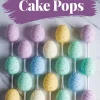 Pastel Easter egg cake pops arranged in a grid on marble, decorated with swirl designs and white sugar pearls in soft shades of purple, yellow, mint green, blue, and peach, with a purple “Easter Egg Cake Pops” text banner above.