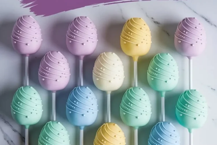 Pastel Easter egg cake pops arranged in a grid on marble, decorated with swirl designs and white sugar pearls in soft shades of purple, yellow, mint green, blue, and peach, with a purple “Easter Egg Cake Pops” text banner above.