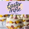 A layered Easter trifle dessert in a glass, featuring alternating layers of whipped cream, diced mango, and strawberries. Topped with pastel-colored speckled chocolate eggs. A lavender banner in the center displays the text “Easter Trifle” with “Recipe Inside.” The background includes additional trifles and soft-focus flowers.