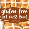 A baking dish filled with soft, gluten-free hot cross buns with raisins and a glossy surface. White icing crosses decorate the top, and a rustic text overlay emphasizes the gluten-free recipe.