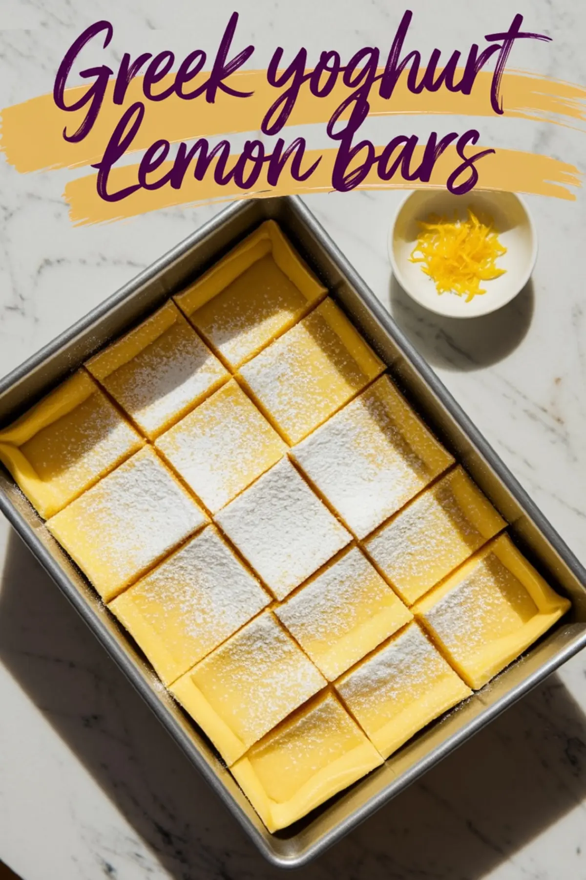 Top-down shot of Greek yogurt lemon bars cut into clean squares inside a baking pan, lightly dusted with powdered sugar, with a bowl of fresh lemon zest nearby and “Greek yoghurt lemon bars” text above.