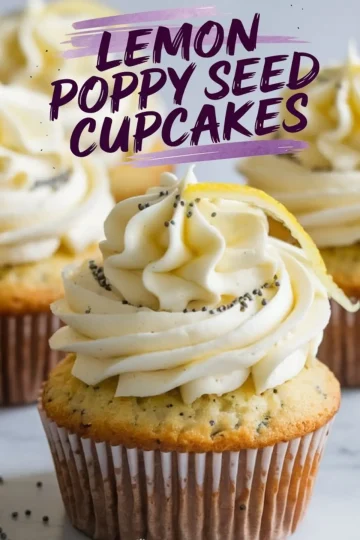 Close-up of a single lemon poppy seed cupcake with smooth buttercream frosting, poppy seeds, and a curled lemon zest garnish. The background features more cupcakes and a marble countertop.